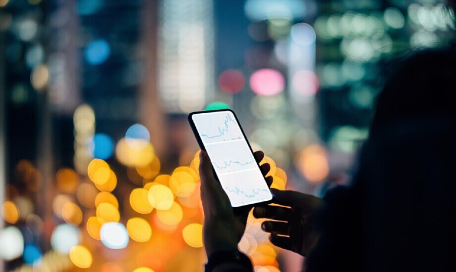 person looking at financial graphs on their phone