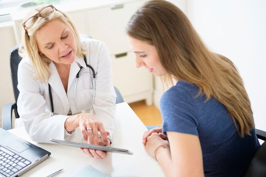 Doctor having a discussion with her patient while looking at a tablet
