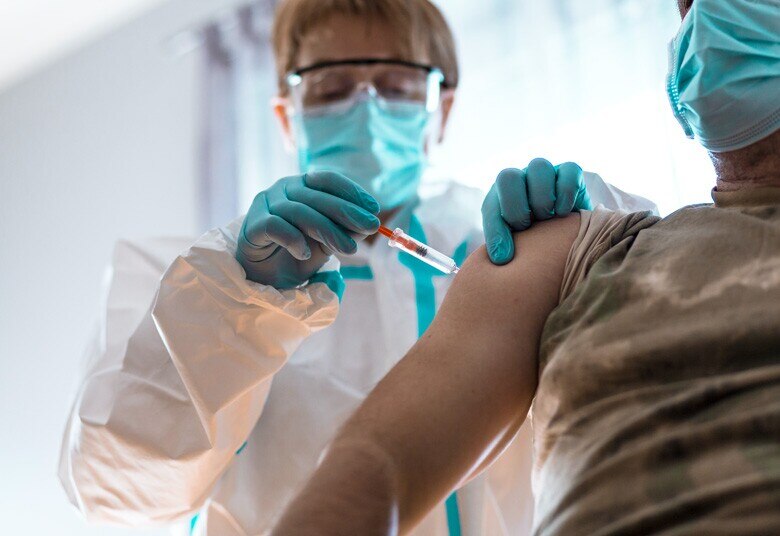 veteran receiving vaccination from doctor