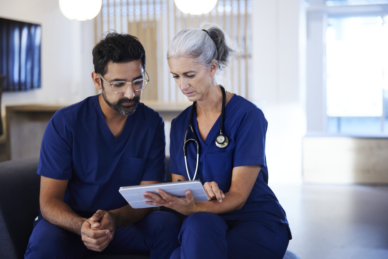 Two doctors working together, looking at digital tablet