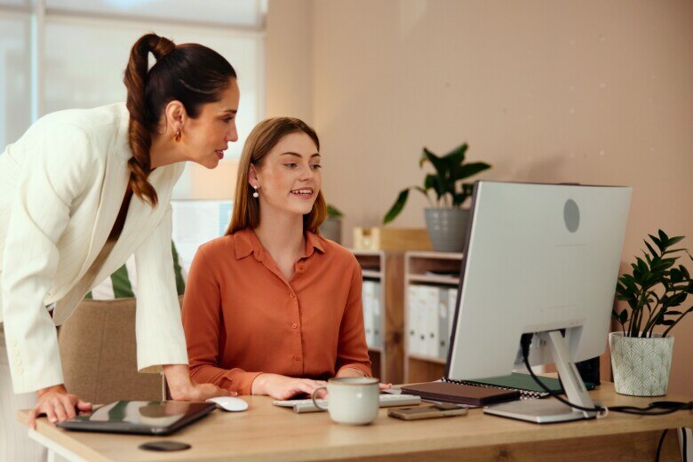 Business Woman and Mentor with computer in office