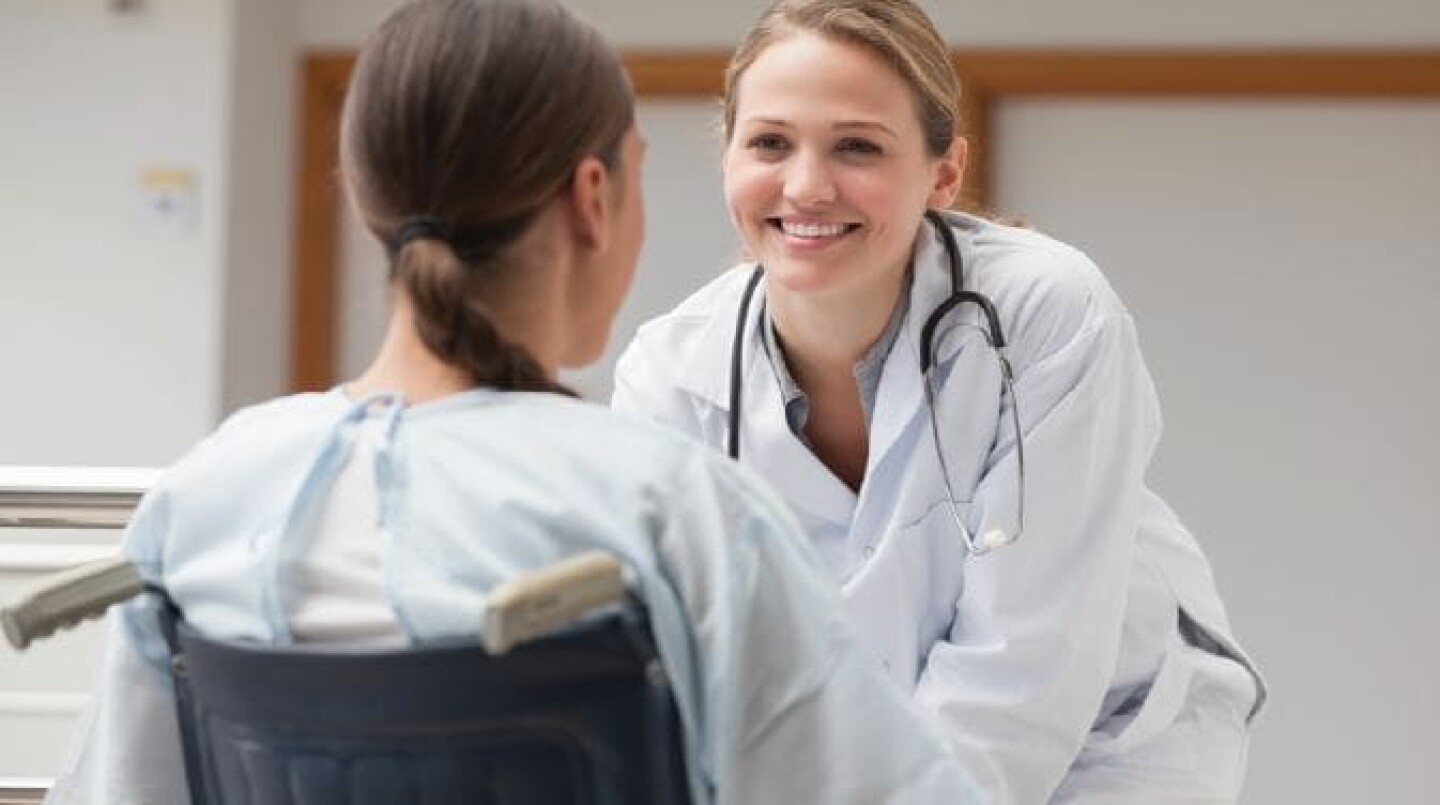 doctor smiling at her patient in a wheel chair