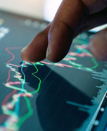 fingers on a touch screen showing a line graph