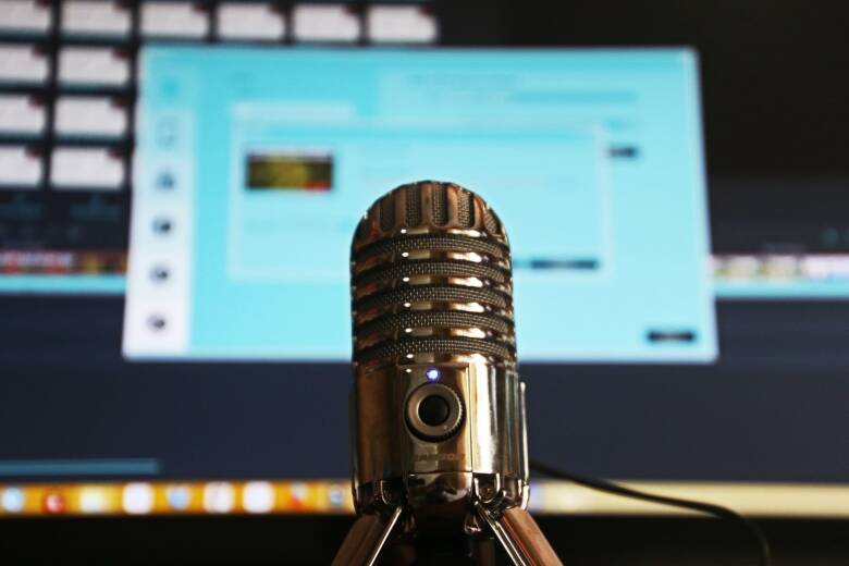 podcast microphone in focus in front of computer screen