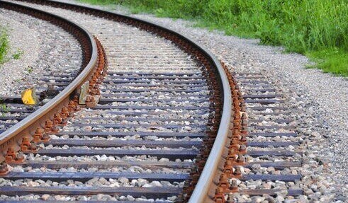 train tracks in a bed of rocks curving slightly to the left