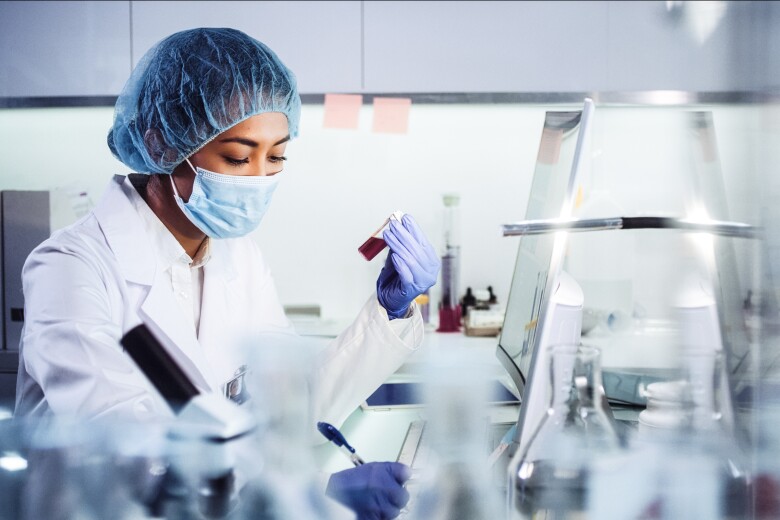 Asian female doctor working with pathogen samples. Using microscope