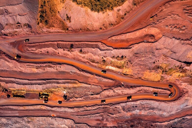 Aerial view of trucks driving along a winding desert road
