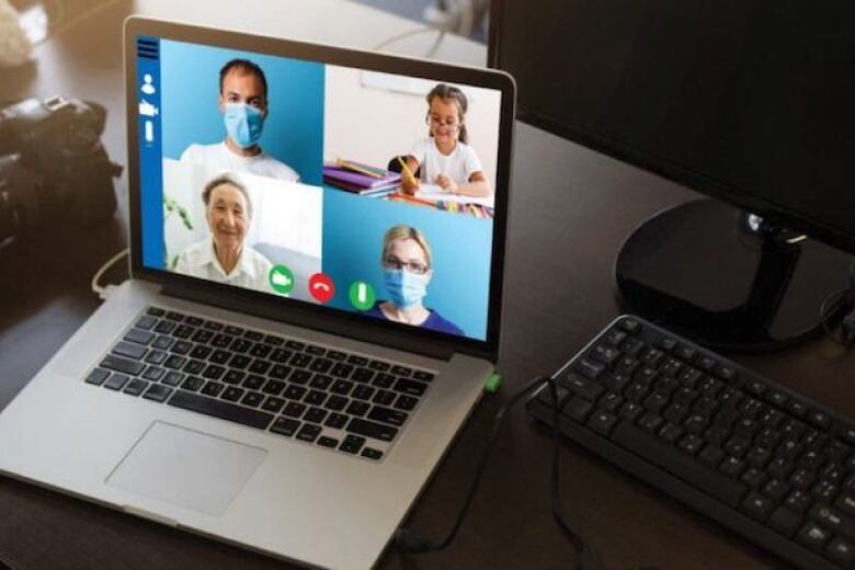 laptop on a desk showing a video call between three providers and a young patient
