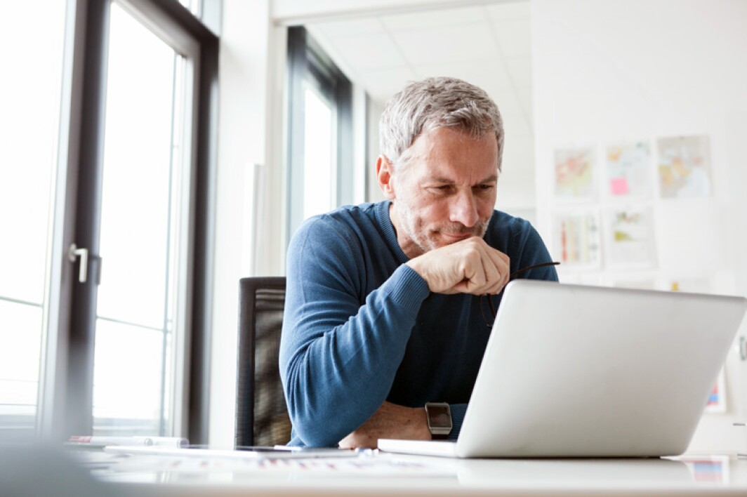 analyst looking pleased as he reviews data on his laptop