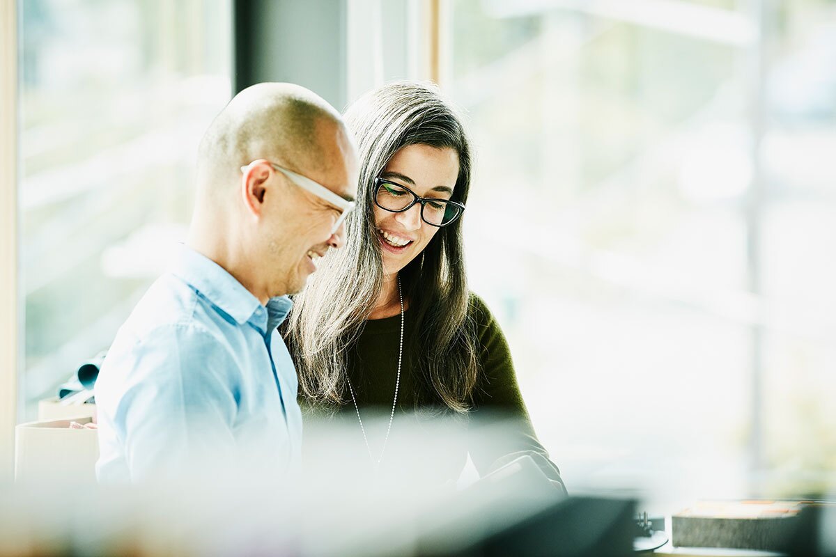 male and female coworkers reviewing information on a shared computer