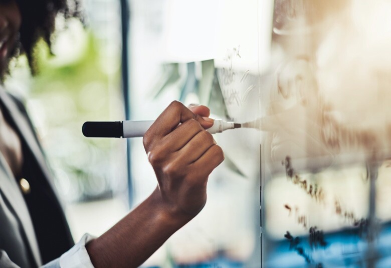 person writing on a whiteboard