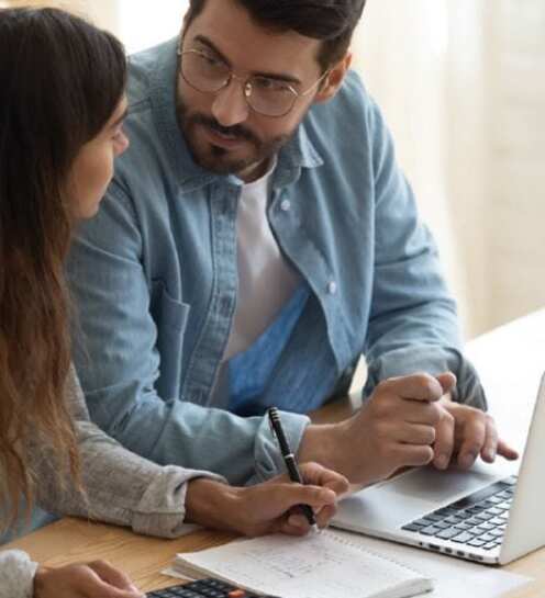 couple discussing their finances while working on a laptop