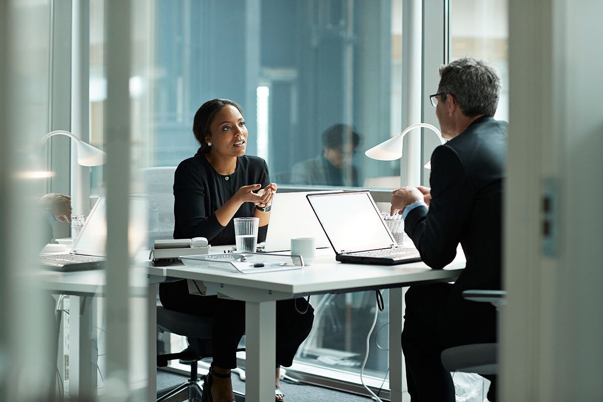 coworkers having a discussion from opposite sides of their shared workspace