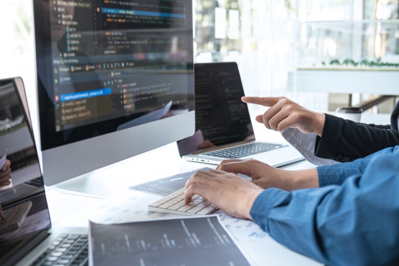 software developers working on code together at a shared desk