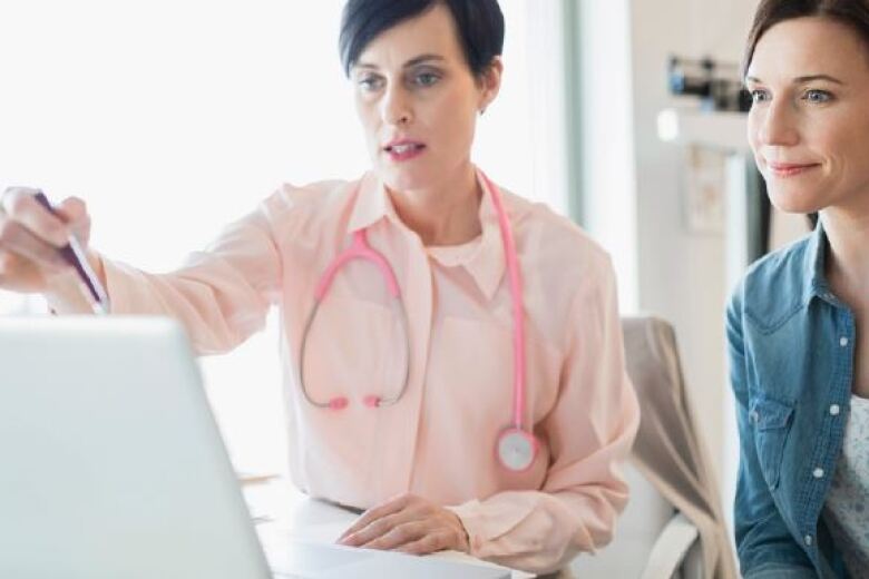 female doctor reviewing information on laptop with female patient