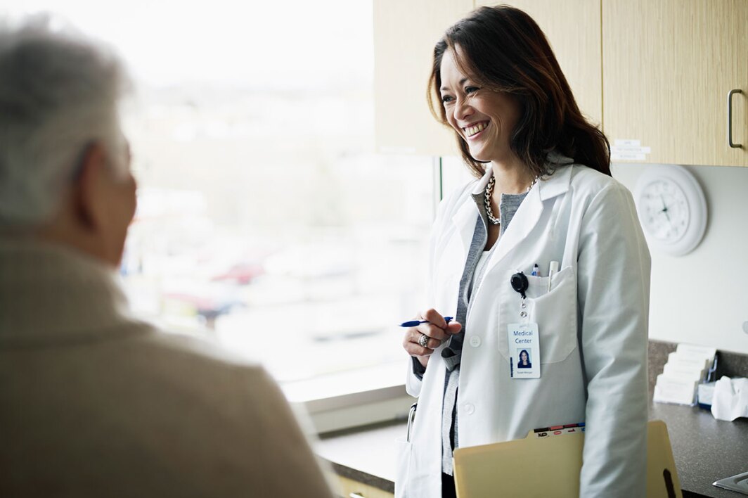 kind doctor smiles while visiting with patient