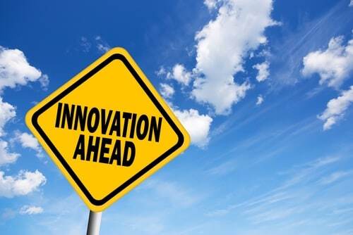 yellow diamond traffic sign reading 'Innovation Ahead' over a blue sky background
