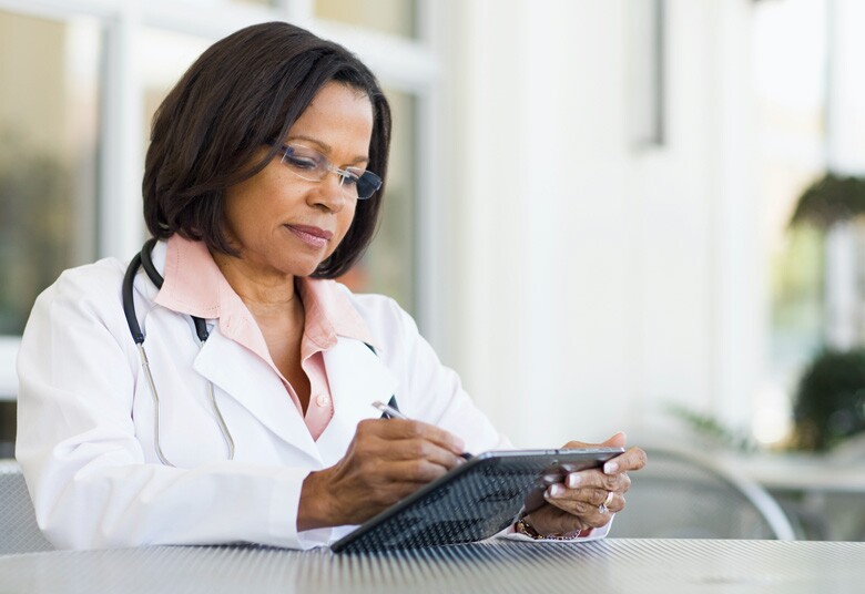 mature doctor using stylus on a tablet