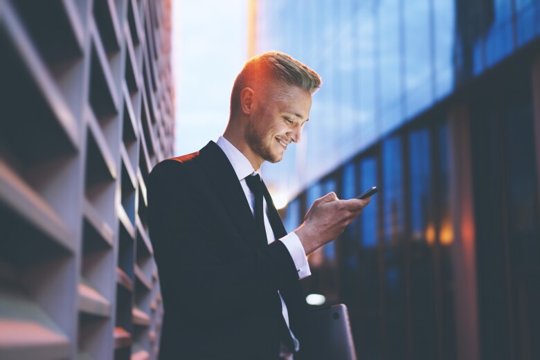 Businessman wearing dark suit looking at his phone