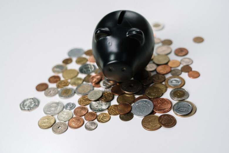 black piggy bank on a pile of spilled change