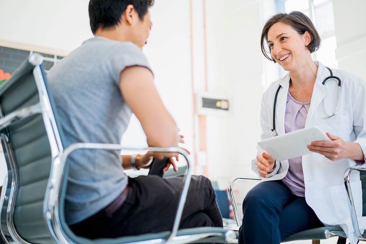 doctor and patient seated facing each other and talking