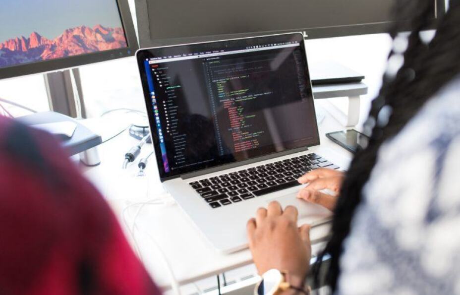 looking over the shoulder of a person using laptop computer to analyze data