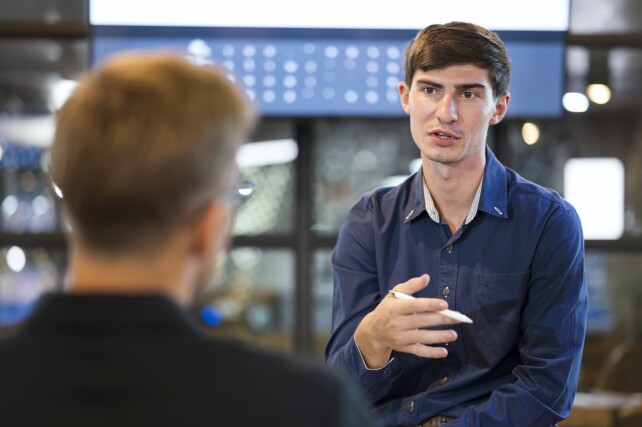 Two male software engineers in a discussion in a modern office
