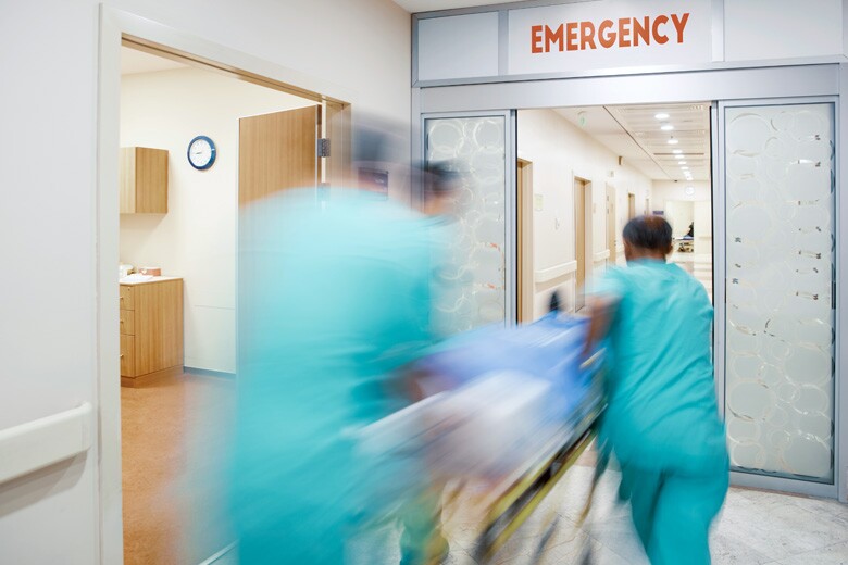 emergency room doctors rushing a patient through sliding doors