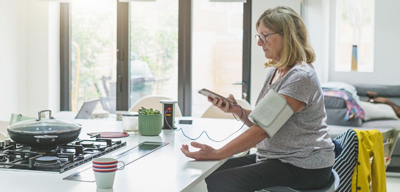 Woman at home checking blood pressure