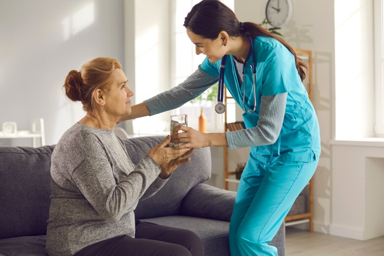 Friendly Young Doctor Visiting Female Patient