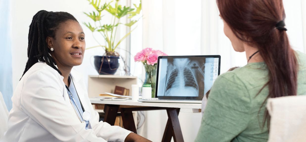 doctor showing patient x-ray images on the computer screen