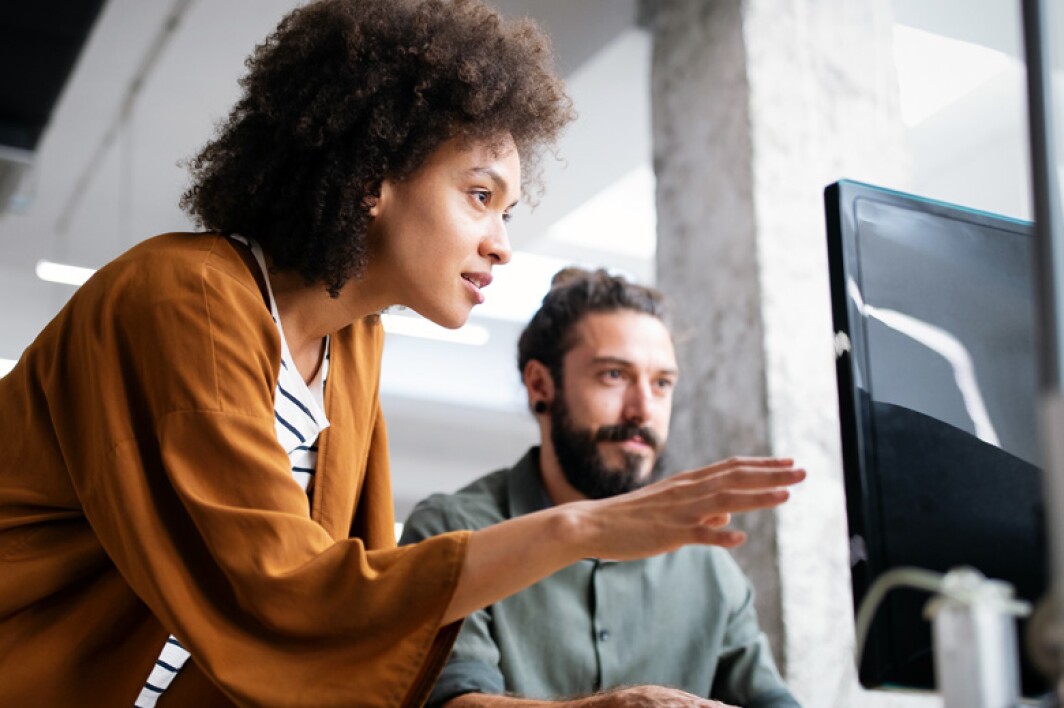 software developers reviewing code on their computer screen