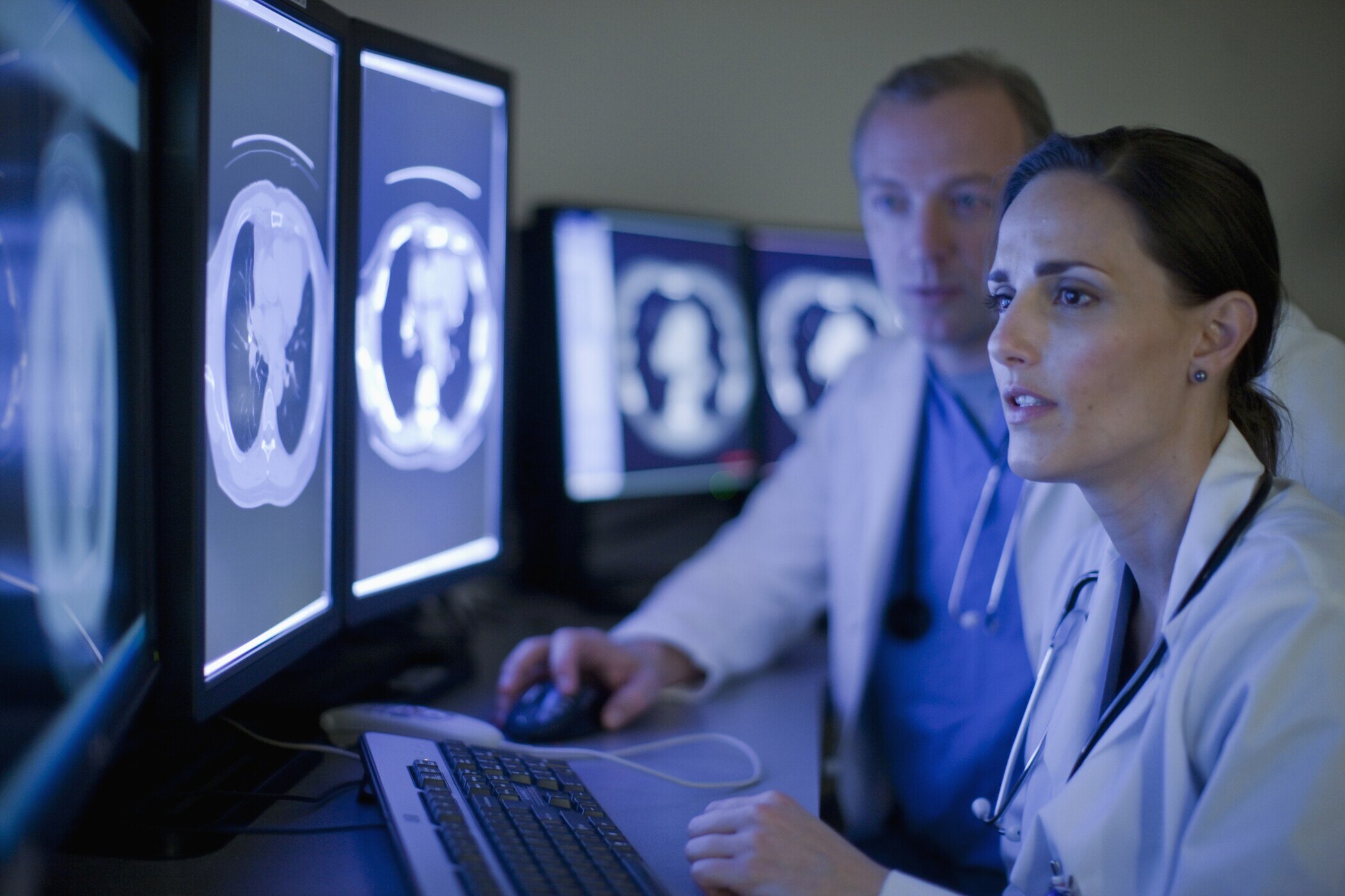 Doctors looking at MRI images on computer screens