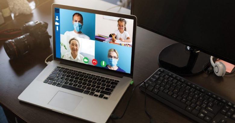 laptop on a desk showing a video call between three providers and a young patient