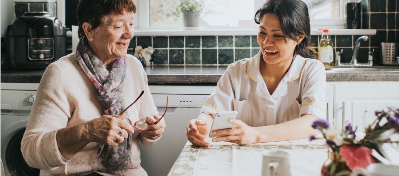 daughter helping senior mother with her smartphone