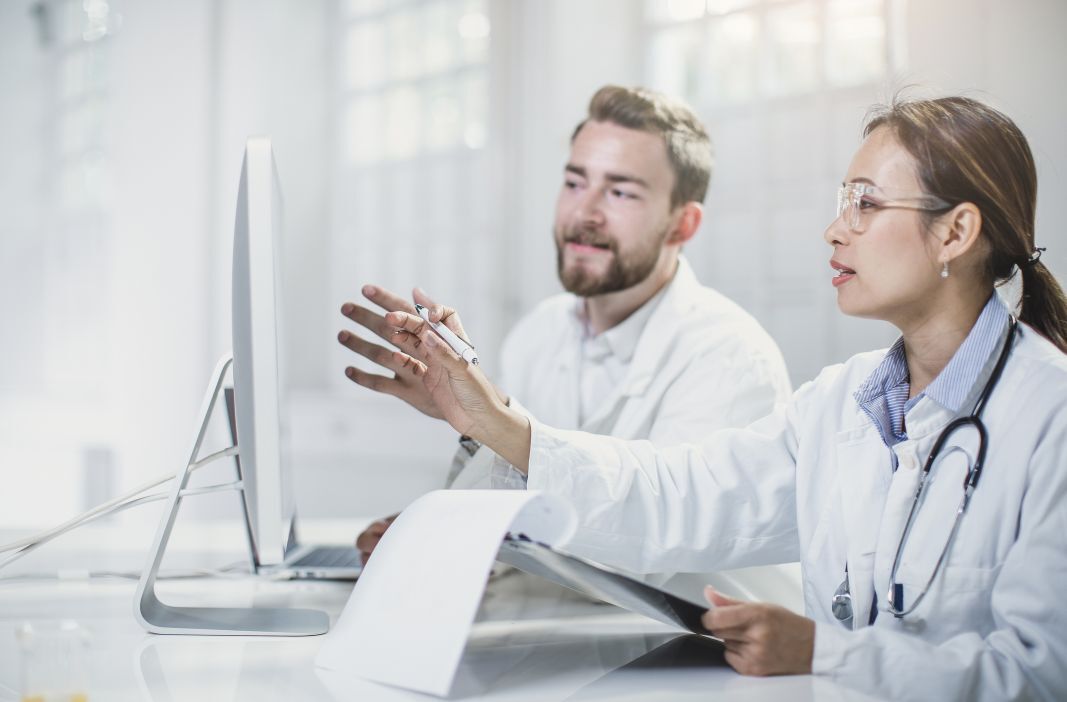 Doctor scientists looking at computer monitor