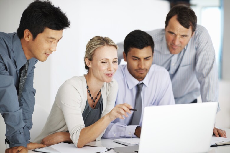 business colleagues gathered around a laptop