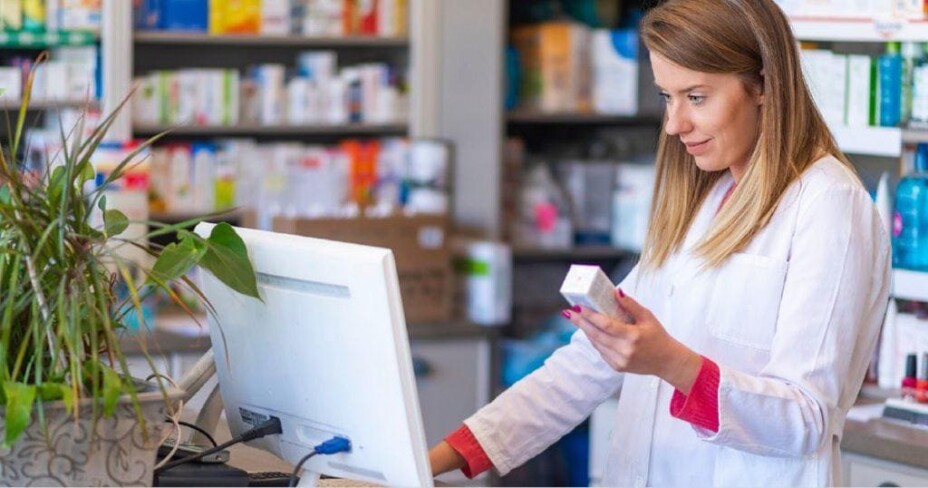 female pharmacist checking medication on computer