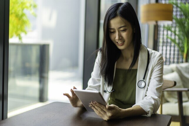 young female doctor using tablet in her office