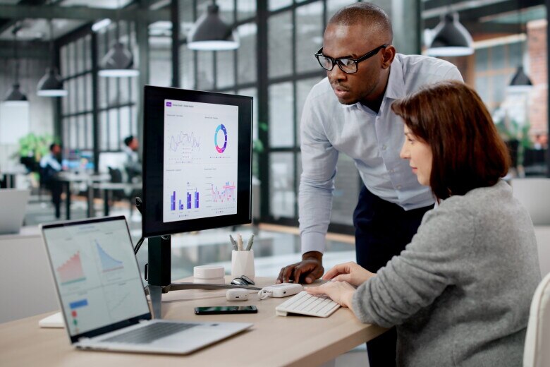 Business Analyst And Marketing Manager Analyze Data On Computer Dashboards