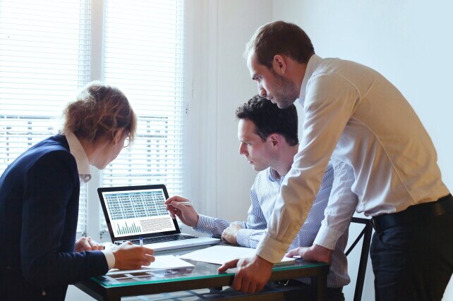 3 people looking at a laptop