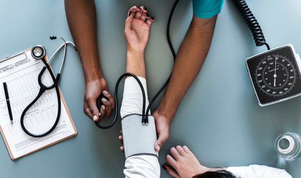 aerial view of a nurse taking the blood pressure of a patient