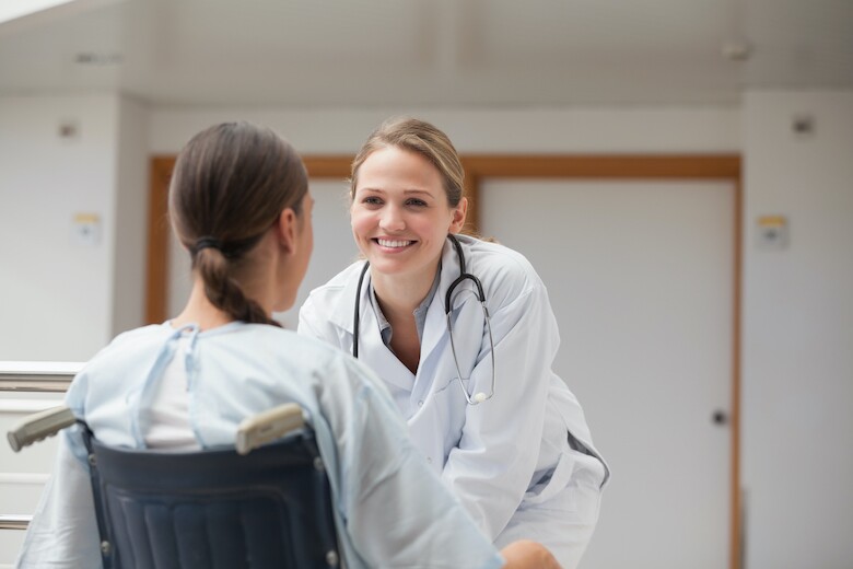 Smiling,Doctor,In,Front,Of,A,Patient,On,A,Wheelchair