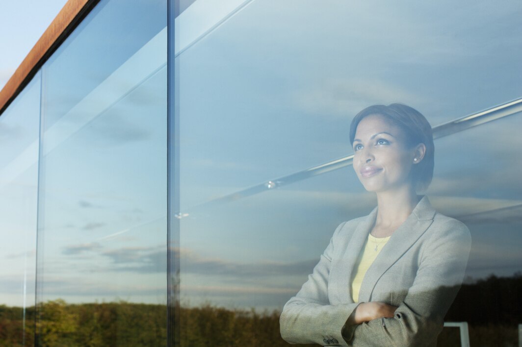 Woman in gray blazer looking out the window