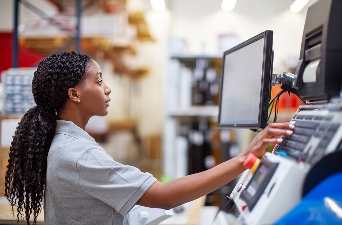 woman operating the computer in large warehouse