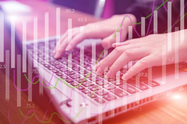 hands typing on a keyboard layered with transparent data graphs