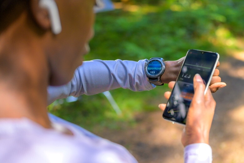 woman synching her smartwatch to her mobile phone