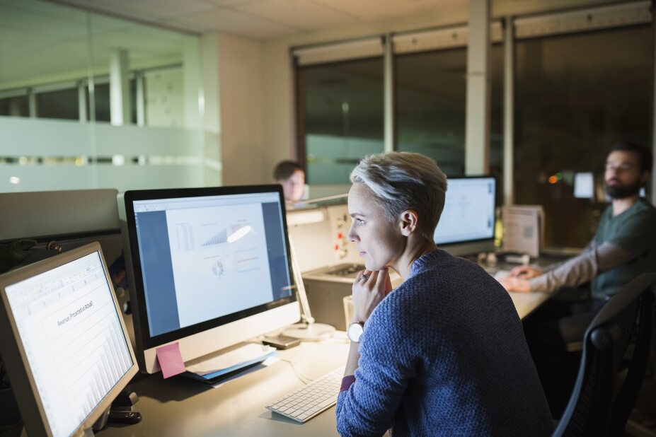 application developer working late with two other colleagues in the office