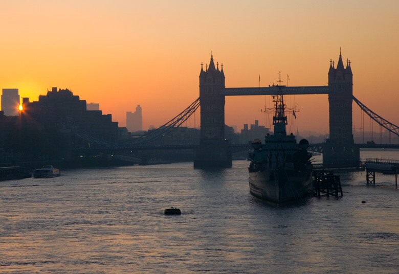 Military ship on the river in front of the Tower Bridge in London