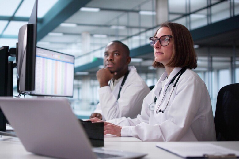 Doctor And Team In Hospital Setting looking at monitors